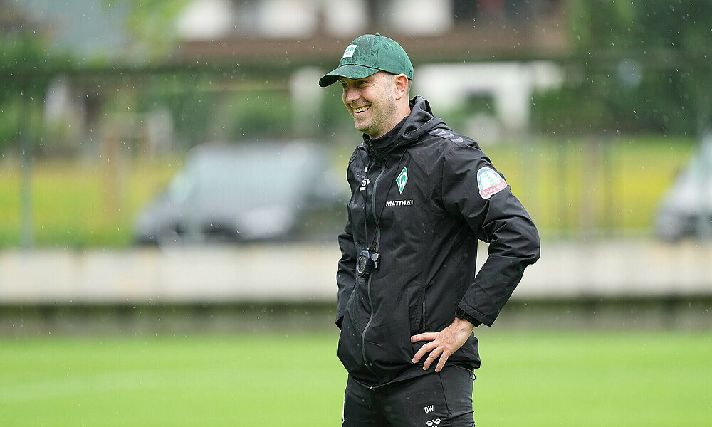 Ole Werner stands on the side of the pitch with his hands on his hips.