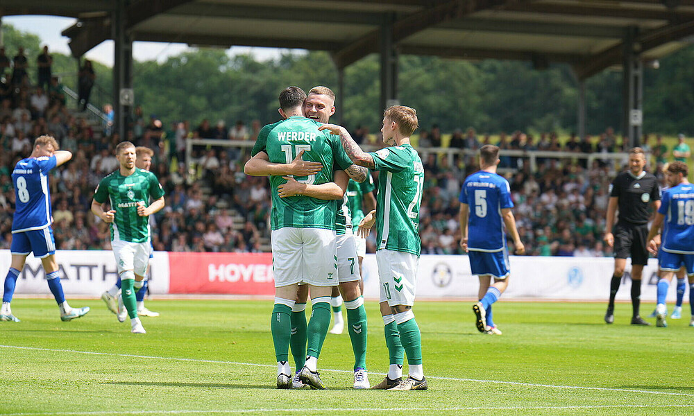 Ducksch and Burke embrace to celebrate the opening goal.