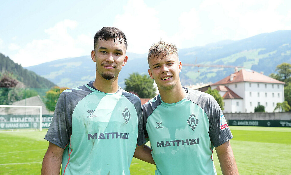 Mio Backhaus and Keke Topp arm in arm on the training pitch.