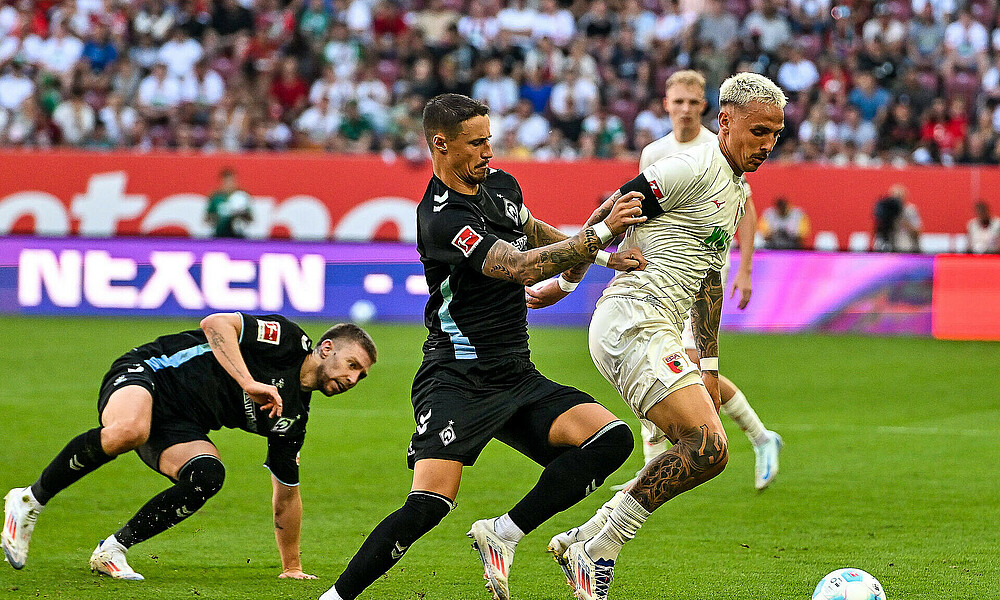 Marco Friedl battling for the ball against an Augsburg player.