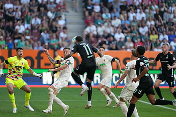 Justin Njinmah sending a header towards the Augsburg goal.