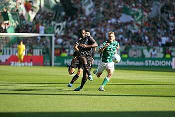 Upamecano battles Marco Grüll for the ball.