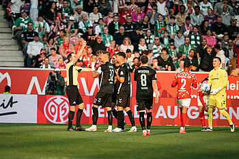 The referee shows the dumbfounded Marco Friedl a red card.