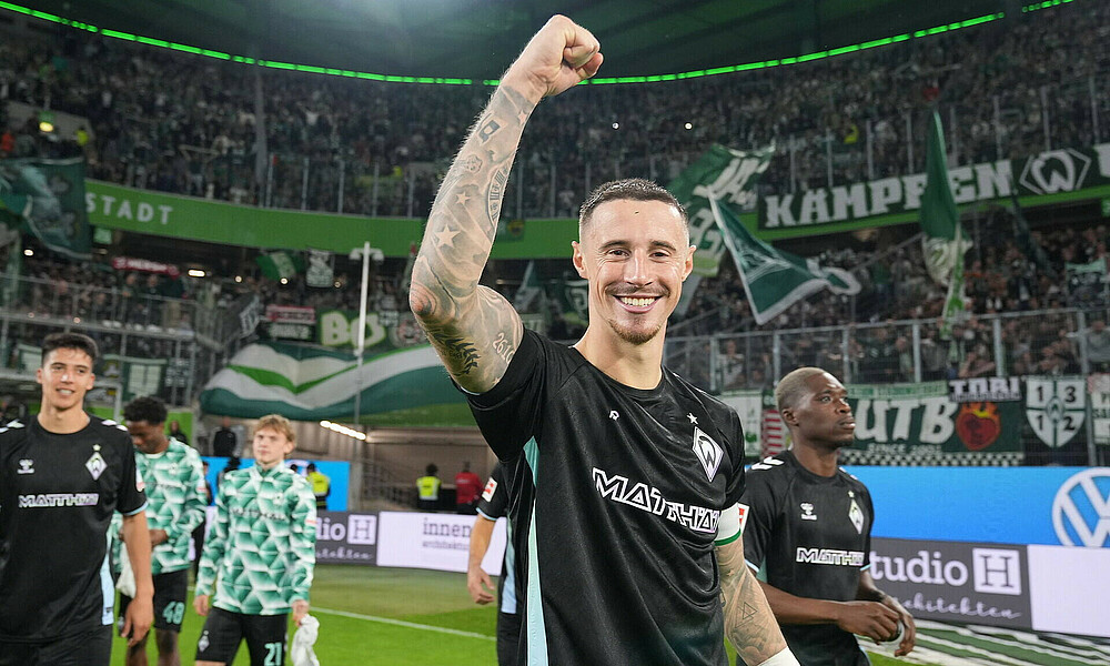 Marco Friedl celebrates with the away fans.