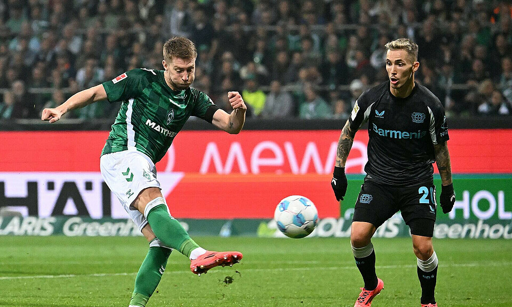 Weiser shoots the ball as Grimaldo watches on.