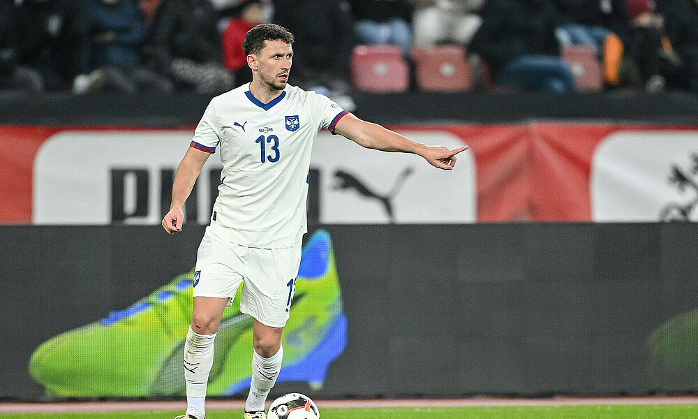 Milos Veljkovic in a Serbia shirt with the ball at his feet.