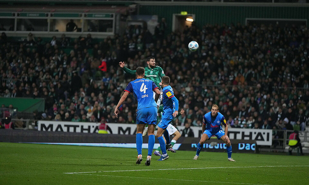 Oliver Burke jumping for a header before scoring his winner against Holstein Kiel