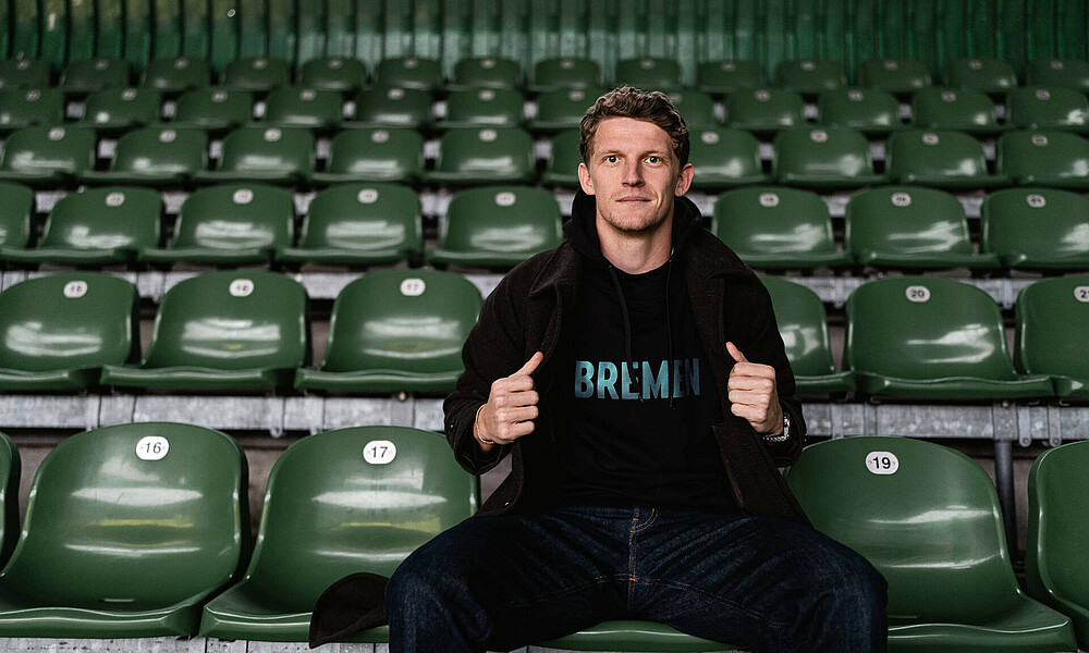 Jens Stage in the stands wearing a Werder jumper.