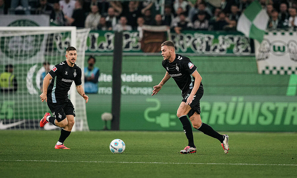 Marvin Ducksch with the ball at his feet, alongside Romano Schmid.