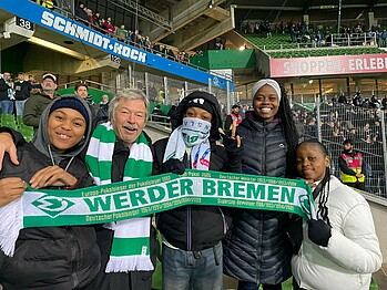 Visitors from the iSithumba Sportsgarden at the Weserstadion holding up a scarf